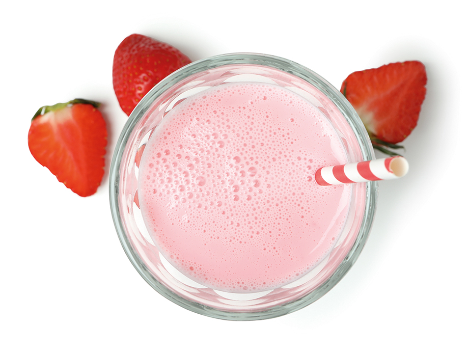 Imagen de un batido de fresa rodeado de fresas